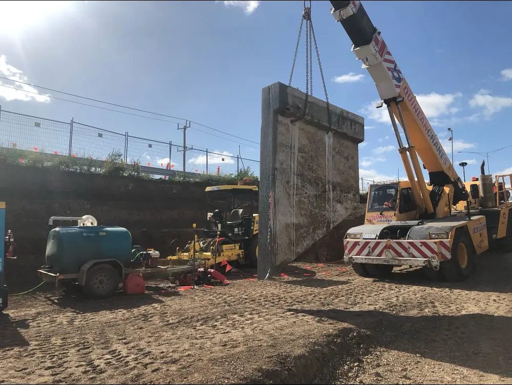 Concrete panel being lifted by crane after cutting
